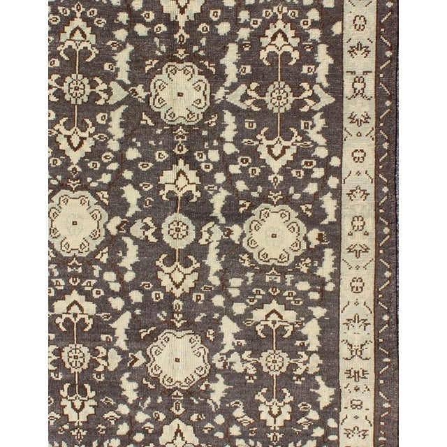 Measures: 3'9 x 5'10. This vintage Oushak was hand-knotted in Turkey during the 1940's. The charcoal/gray background dark...