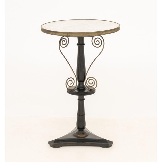 French White Marble Top and Ebonized Wood Gueridon, with brass scroll work motif on trefoil base. 26" H x 16.75" Diameter....