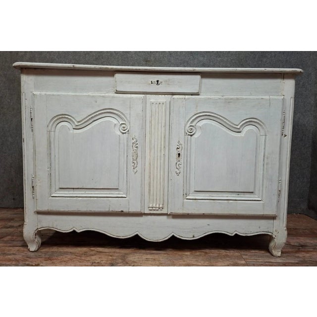 Small rustic Louis XV period sideboard in natural wood with an antique off-white patina. The front opens with two molded...