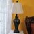 Vintage traditional fluted urn table lamp crafted from molded resin with an antique carved wood appearance. The ribbed urn...