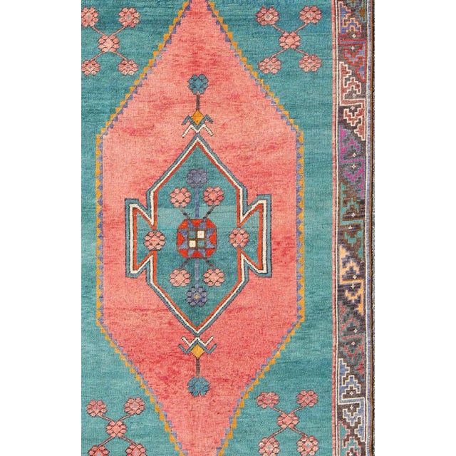 Measures: 5'2 x 8'7 Colorful Turkish medallion with tribal design in teal, coral, background and complemented by deep...