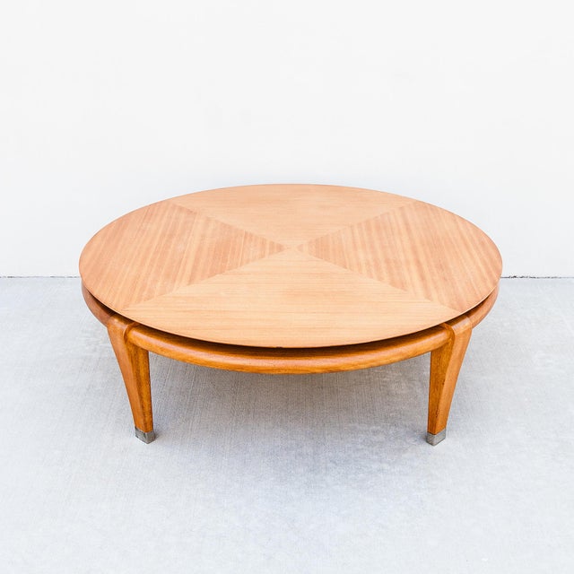 Expertly refinished mid century modern blonde mahogany cocktail table with polished nickel sabots. Produced by Brown...