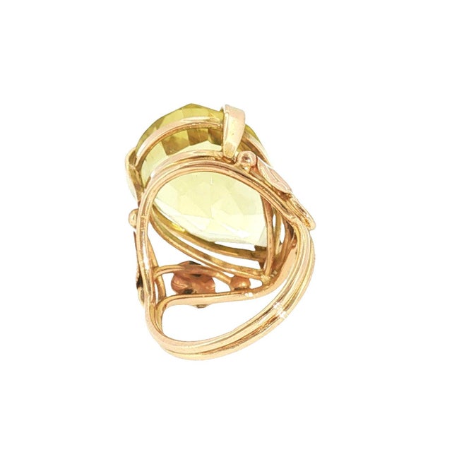 A late 20th-century statement ring featuring an approximately 15.0 carat pear-cut citrine. The stone is a vibrant yellow,...