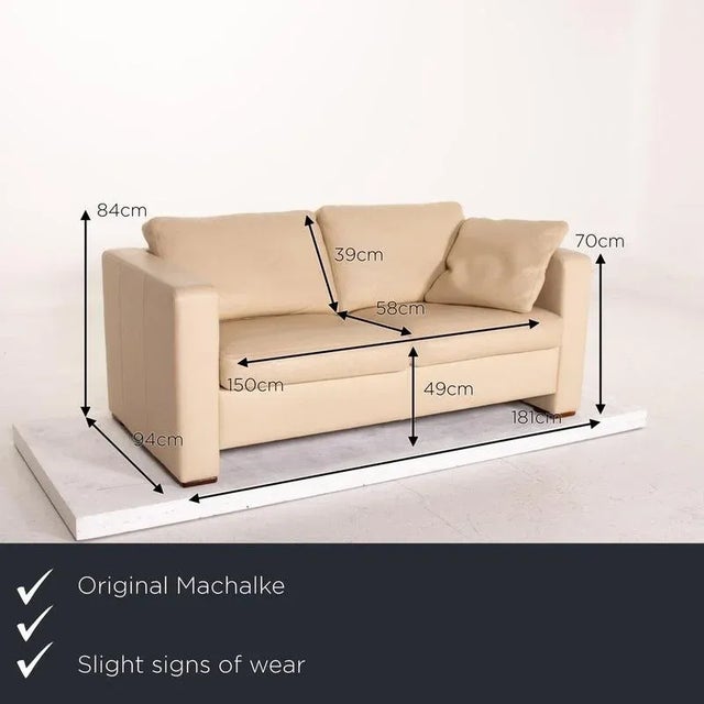 The two-seater from Machalke is upholstered in beige genuine leather and completely covered in it. Clean lines and a...