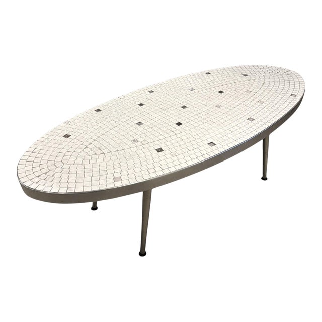An atomic style surfboard shaped coffee table in the manner of Gordon Martz. The table top is decorated with tessellated...
