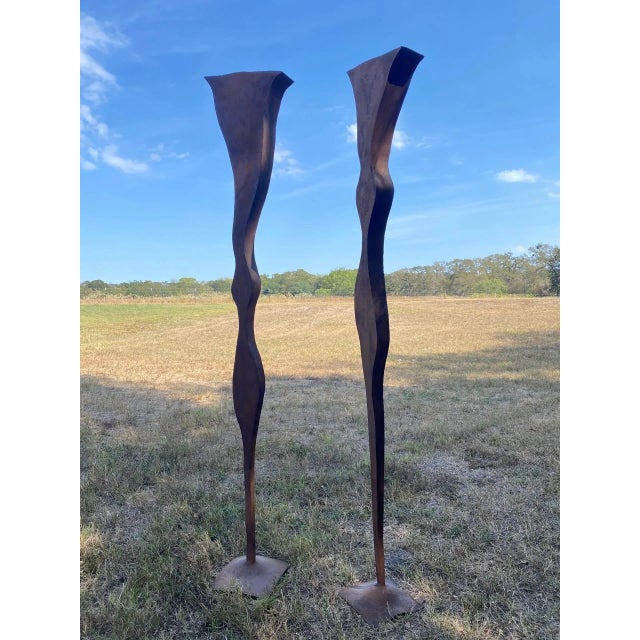 Monumental pair of welded and oxidized steel sculptures, likely executed in Corten or a similar weathering steel. Entirely...