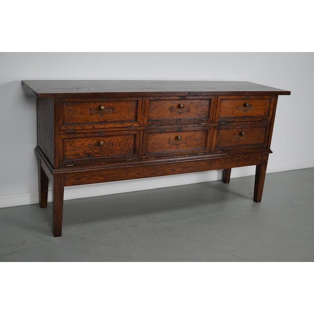 This French oak cabinet was designed and made, circa 1920 in France. It features 6 compartments with drop down doors that...