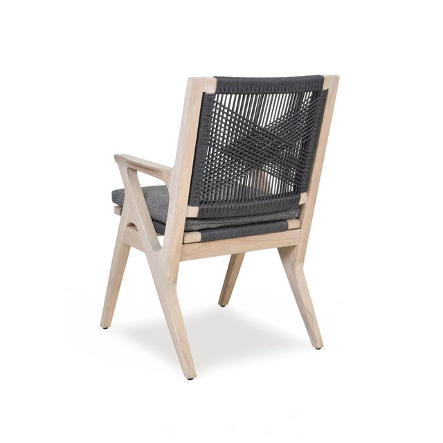 A sleek dining chair adapted from a Hans Wegner original featuring a teak and woven rope frame supporting a removable...