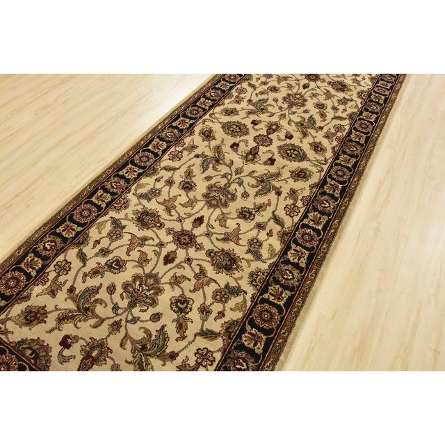 A traditional Agra runner hand-knotted with an all-wool pile on a cotton foundation. This finely woven oriental rug...