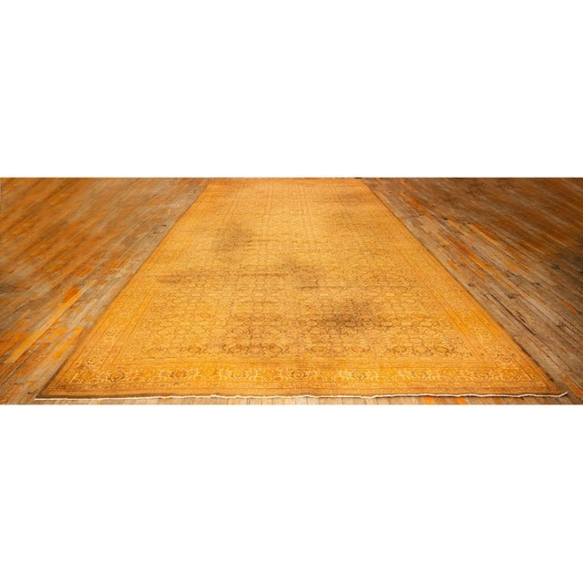 This mid-20th-century hand-knotted Indian decorative rug features a bold, large-scale floral design with a controlled...