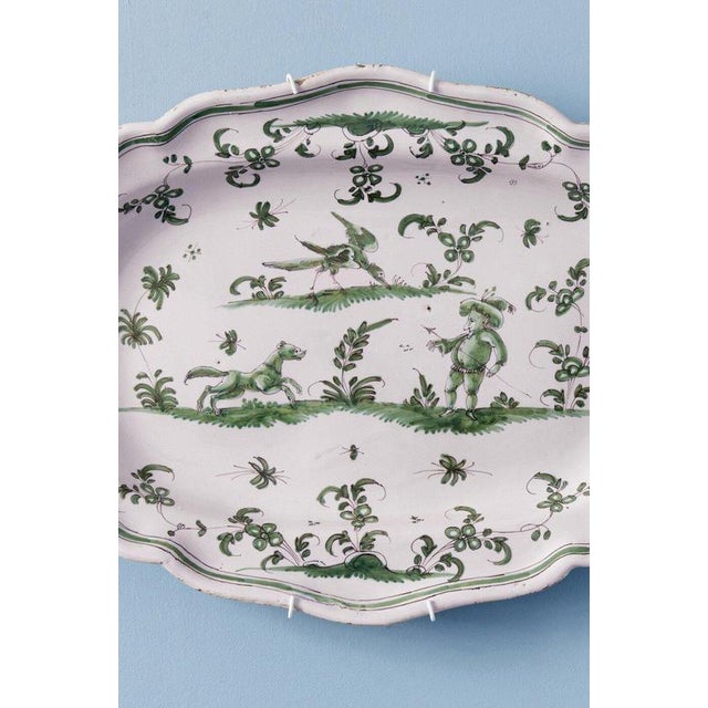 This mid-18th-century French faience dish from Moustiers, c. 1740–1760, is decorated in a harmonious camaïeu of greens...