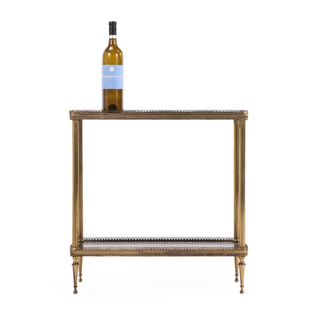 Elegant pair of mid-century French brass tables, each composed of two tiers fitted with black marble shelves. The brass...