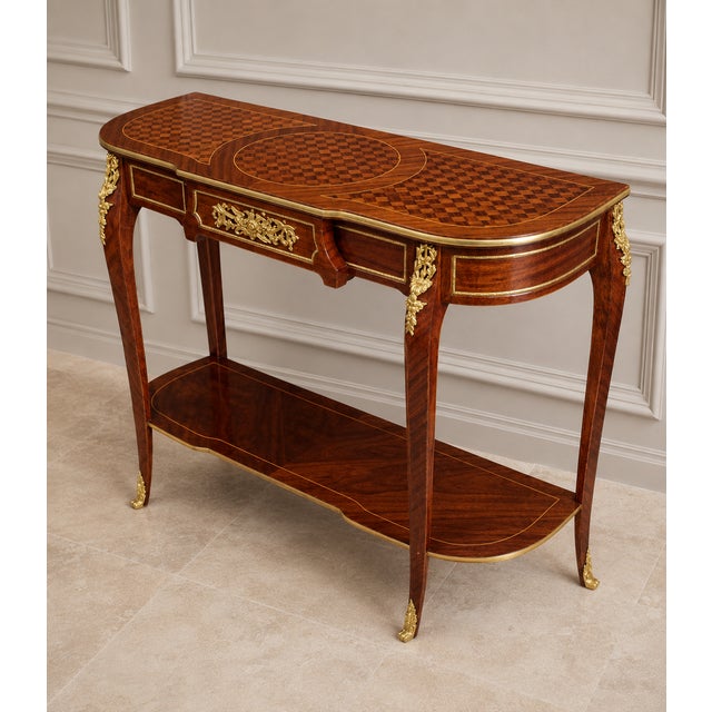 Elegant French Louis XVI-style console table crafted in richly figured wood with exquisite decorative marquetry and...