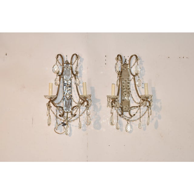 Wonderful pair of mirrored wall sconces with two arms, joined by graceful glass beaded swags and finished with hanging...
