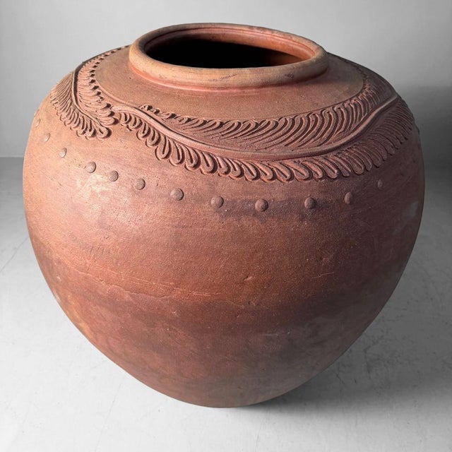 This monumental Japanese terracotta jar has a wide, almost spherical body, a stable foot, and a generous opening with a...