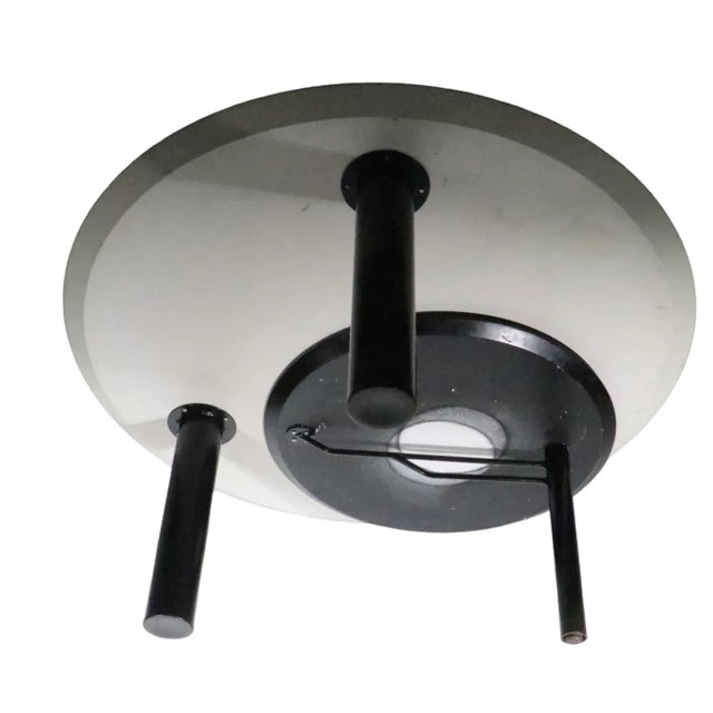 Chic architectural post modern coffee table featuring a large round white upper surface, with swing out lower, smaller,...