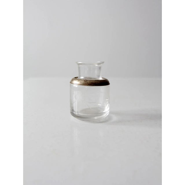 This is an antique etched glass bottle. The art nouveau jar features a silver tone metal shoulder with a beautifully...