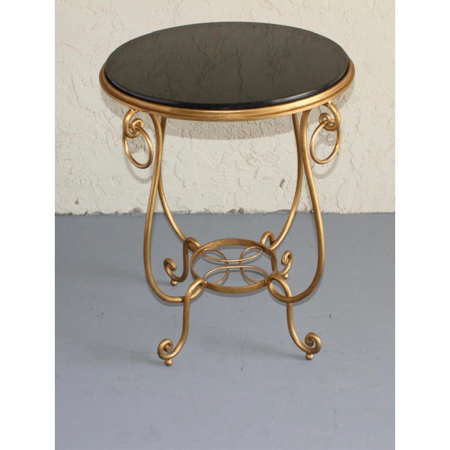 Elegant vintage accent table crafted in the style of famed French designer René Drouet, featuring a sculptural gilt iron...