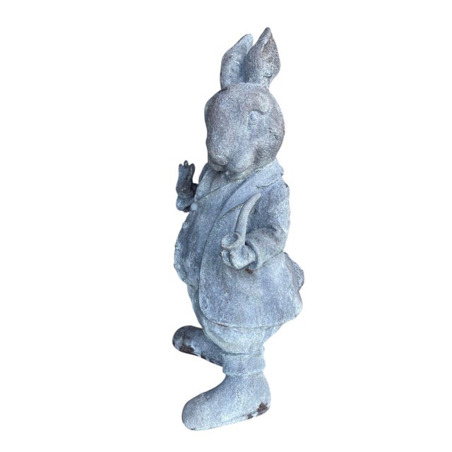 This striking garden sculpture features a sophisticated anthropomorphic rabbit captured in a whimsical, mid-stride pose....