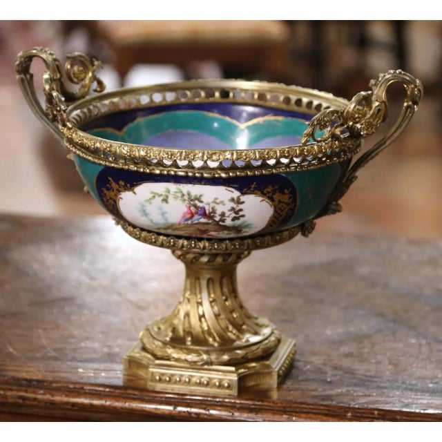 Crafted in Paris circa 1860, this elegant antique Sèvres-style jardinière features a richly mounted gilt bronze frame...