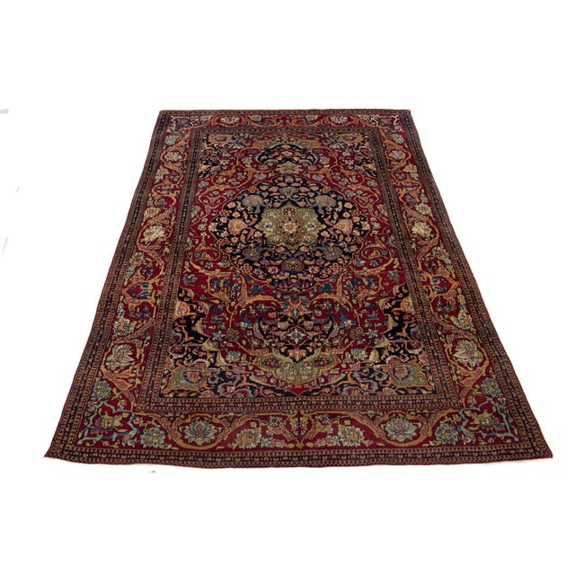 This hand-knotted wool rug is a remarkable antique from the 1920s, featuring a vibrant floral design in various colors...