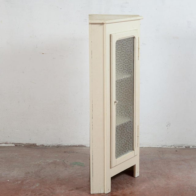 This small corner display cabinet is a charming example of vintage furniture, ideal for those who appreciate the appeal of...