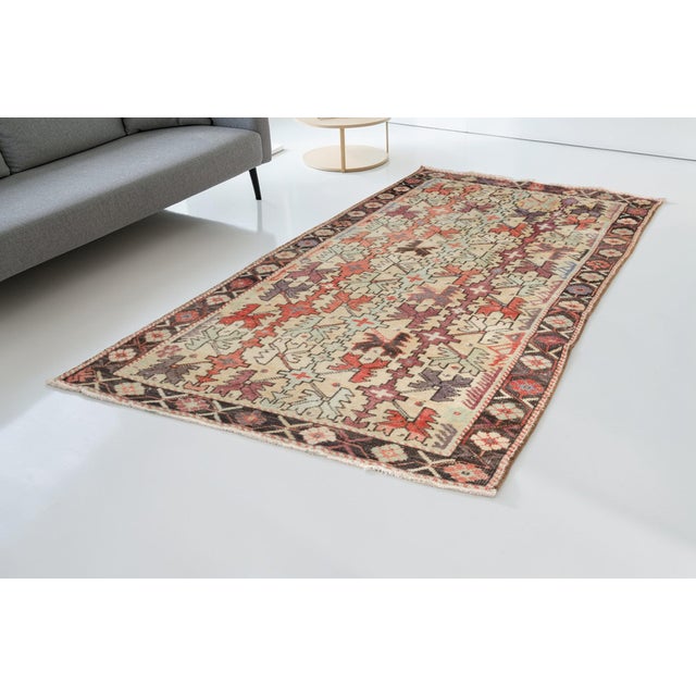 This is a vintage Turkish Oushak rug from the Mid 20th Century. The piece was hand-knotted.