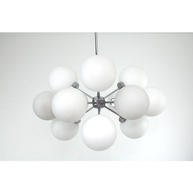 Gestell Messing verchromt, 12 matte weiße Opalglaskugeln, 12 Fassungen E14 This piece is attributed to the mentioned...