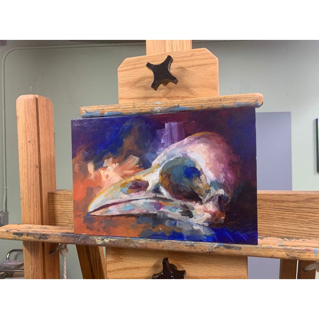 The artwork features a crow skull rendered in vibrant oil colors on aluminum, showcasing a striking interplay of light and...
