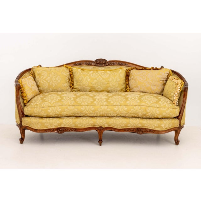 Louis XV Yellow Silk Damask Upholstered Walnut Sofa, the carved wood frame with floral motifs. 34" H x 74" W x 31" D;...