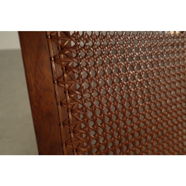 A refined mid-century modern lounge chair crafted in solid teak, featuring a beautifully integrated cane seat and...