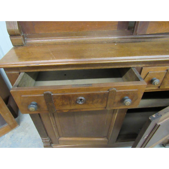 Impressive antique walnut step-back china cabinet featuring a tall, stately profile and beautiful traditional...