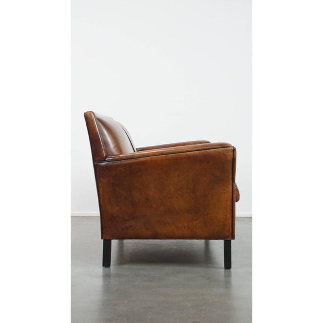 Offered is this stylish sheep leather 2 seater Art Deco sofa with a black piping finish. This amazing sheep leather Art...