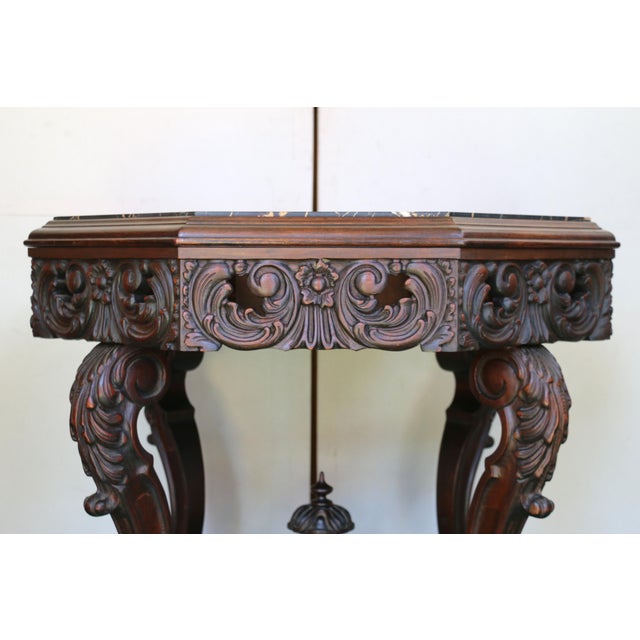 Stunning antique Victorian walnut center table, characterized by its ornate design and fine craftsmanship typical of the...