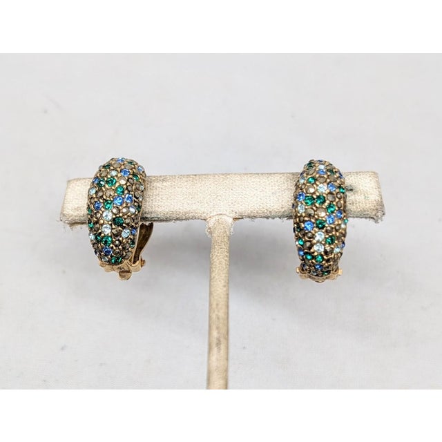1980s goldtone pavé rivoli faux-hematite with round light and dark blue and green rhinestones half hoop clip earrings....
