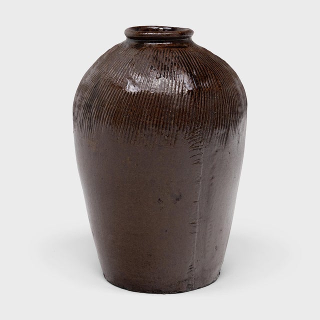 This large ceramic jar is a vintage Chinese wine vessel from the early 20th century, originally used for aging wine and...