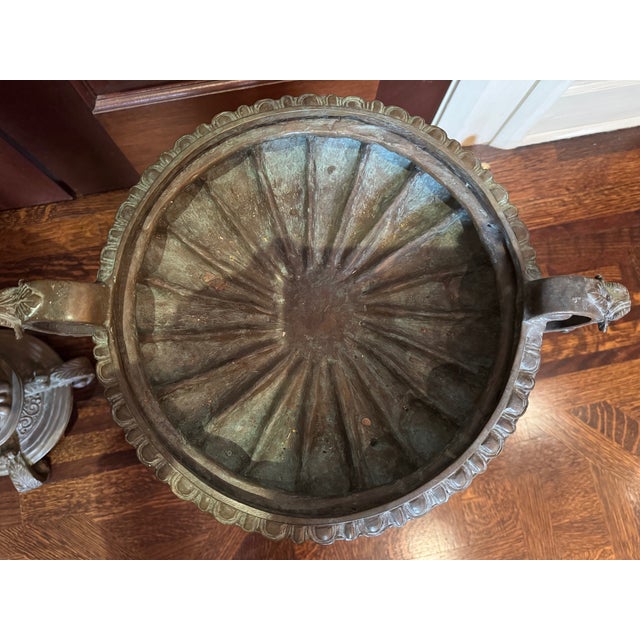 A dramatic and architecturally scaled pair of Neoclassical-style bronze urn planters, richly detailed and sculptural in...