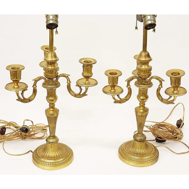 Finely gilded in 23k gold, a pair of 19c French L. XVI style candleabras made into table lamps. His and Hers with 1 lamp...