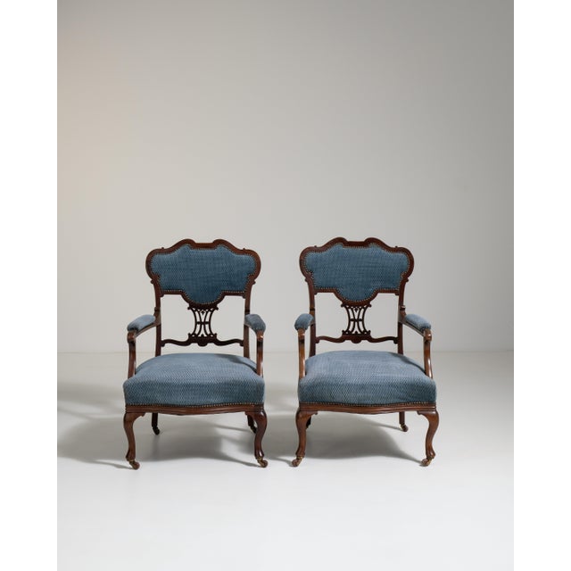 A decorative pair of Louis XV style armchairs featuring curved lines and refined proportions rooted in Rococo design. The...