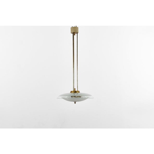 Rare and very beautiful circular chandelier made in curved glass, with polished brass elements attributed to Pietro Chiesa...