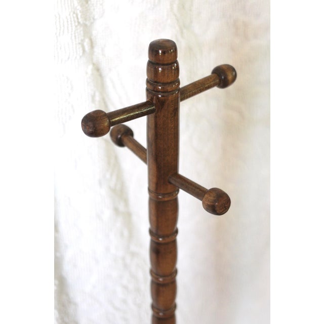 A small stool with an attached hanger. Handmade with turned wood details and knobs. Great for plants or as a convenient...