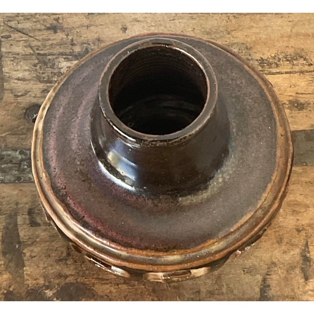 This vintage studio art pottery vase is a compelling example of 1970s Brutalist design, merging ancient motifs with a...