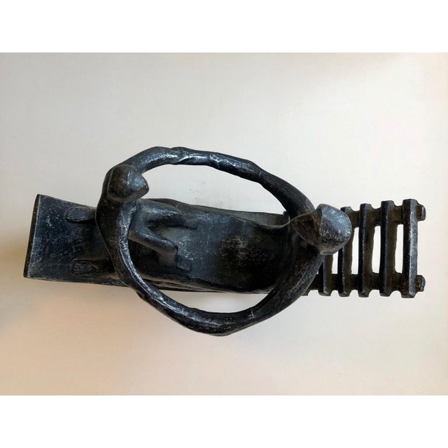 This is a cast metal sculpture of a woman and child, mother and baby in a rocking chair. It has a patina on a white metal....