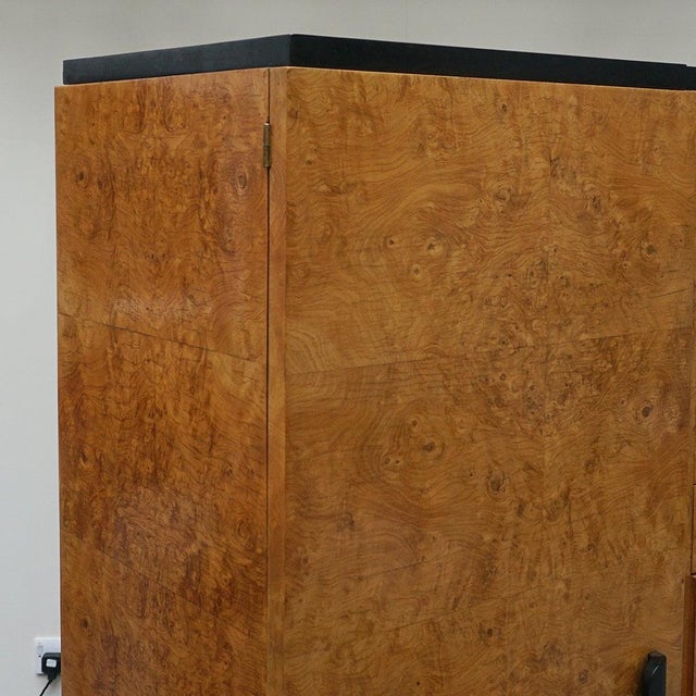 An Art Deco three sectioned dressing cupboard. Central variegated drawers flanked by to interior mirrored shelving...