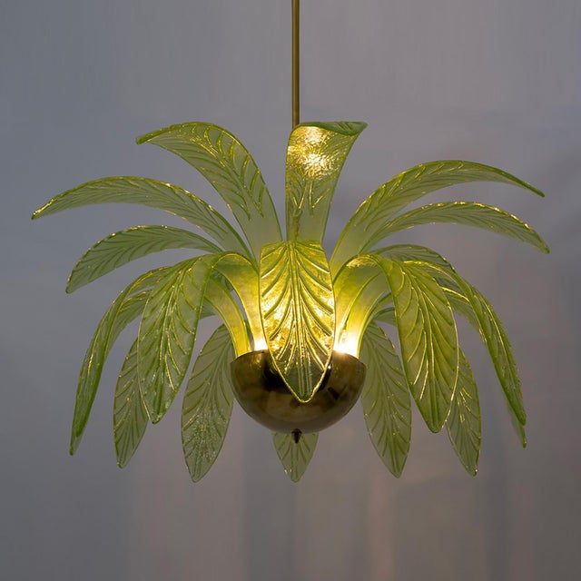 Mouth blown murano glass chandelier, green murano glass leaves, brass frame, three light bulbs. The chandelier reproduces...