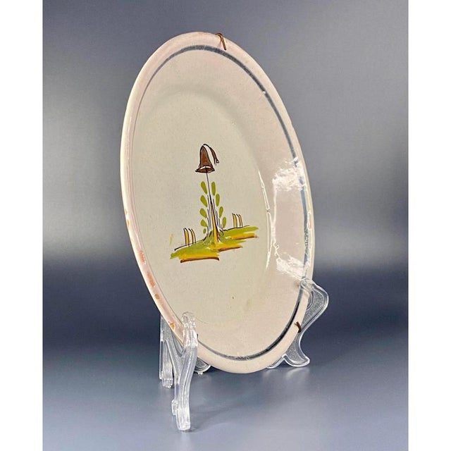 A late 18th-century French faience plate from Nevers, decorated with a hunting hat on a branch in the centre. The vibrant...