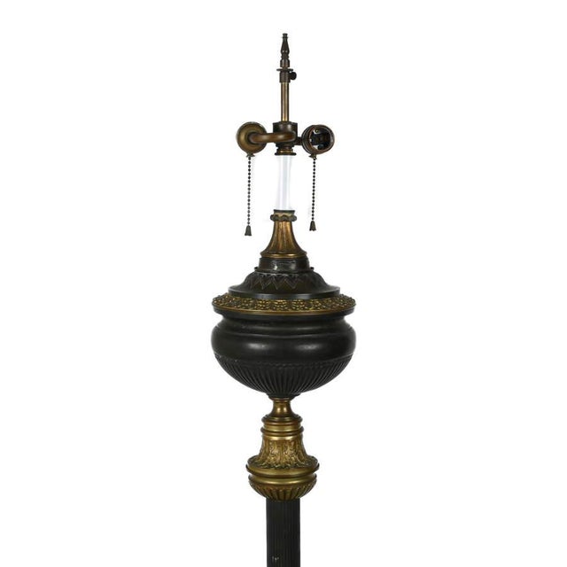A striking Neoclassical Revival floor lamp with integrated table, dating from the 1920s–1940s. This elegant piece features...
