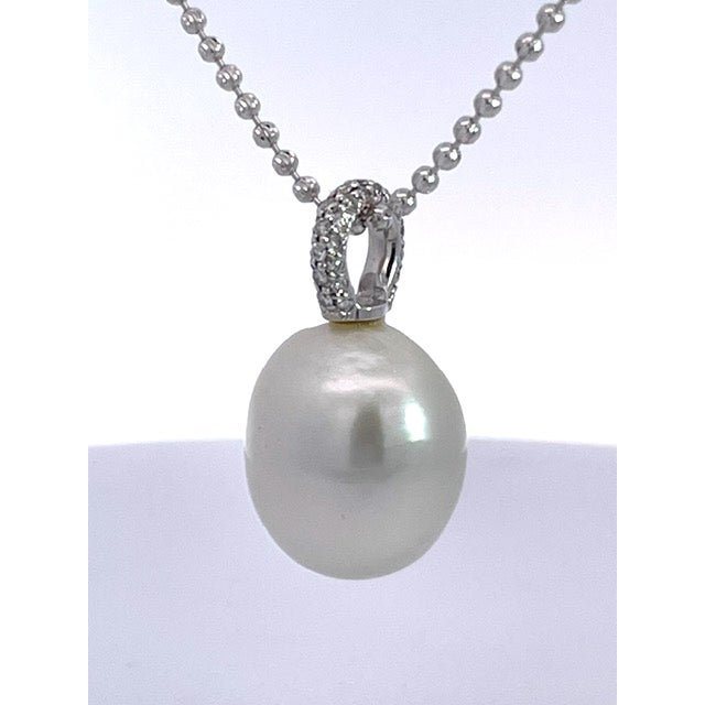 A large, luminous baroque pearl anchors this classic pendant, its soft ivory-white surface glowing with subtle rosé and...