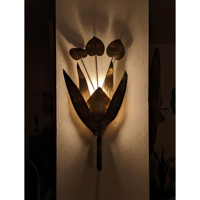 Wall sconce executed in brass during the 1960s, designed within the parameters of the Hollywood Regency style. The fixture...