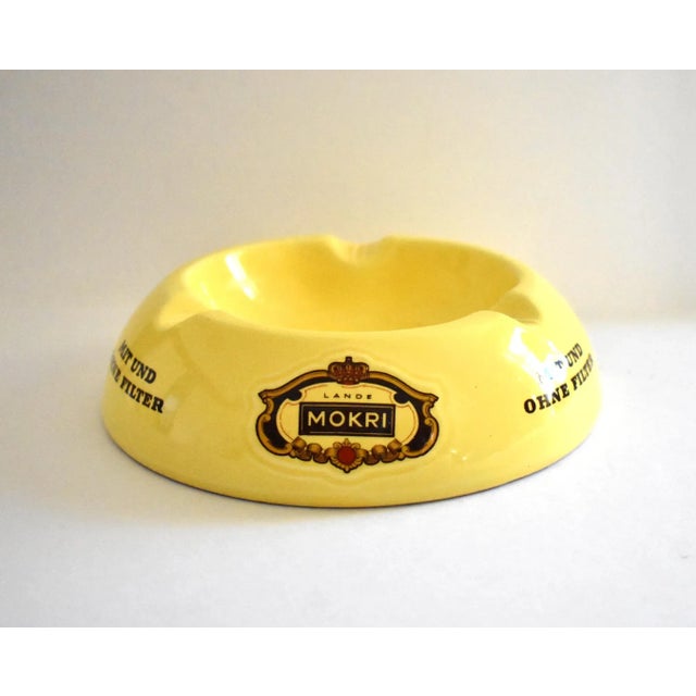 A vintage, mid-century, c. 1960s German bright yellow ceramic publicity or advertising ashtray for cigars and cigarettes...